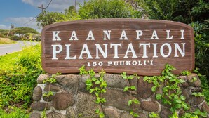 A wooden sign with the text "Kaanapali Plantation 150 Puukoli'i" surrounded by greenery. - Kaanapali Plantation by Coldwell Banker Island Vacations (Lahaina)