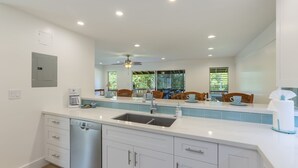A modern kitchen with a dishwasher, double sink, and a ceiling fan. - Kaanapali Plantation by Coldwell Banker Island Vacations (Lahaina)