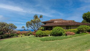 A house with a sloped roof, surrounded by well-maintained lawns and various shrubs. - Kaanapali Plantation by Coldwell Banker Island Vacations (Lahaina)