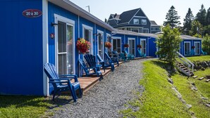 A row of blue chairs outside a building with a sign reading "20 a 30". - Navigateur Ste-Luce (Sainte-Luce)