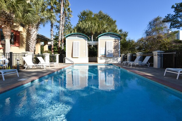 Relax by the pool surrounded by lush greenery and comfortable lounge chairs.
