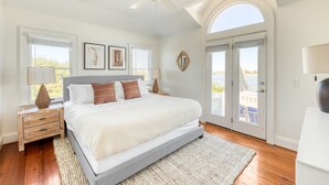 A bedroom with a large bed, a ceiling fan, a view through the door, and a window with blinds. - Haven by AvantStay | Luxury Beachfront Home w/ Pool & Gorgeous Patios (Sullivans Island)