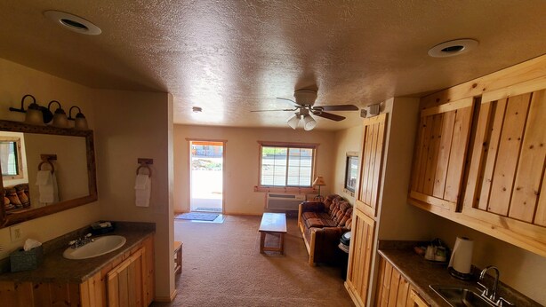 A spacious bathroom with wooden cabinets, a sink, and a shower area.