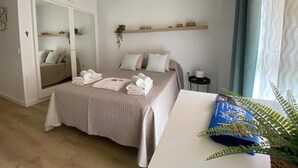 A bedroom with a bed, a wardrobe, a bedside table, and a window with curtains. - Benal Beach (Benalmádena)