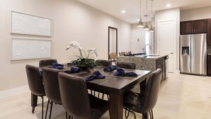 A modern kitchen with a dining area, stainless steel appliances, and a large island. - Comfy Villa | 5 Min to Dinsey! Hot Tub & BBQ* (Kissimmee)