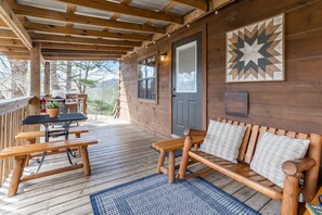 A wooden deck with a picnic table, a bench, and a door. - Honeymoon Log Cabin w/ Wooded Mountain Views (Hot Springs)