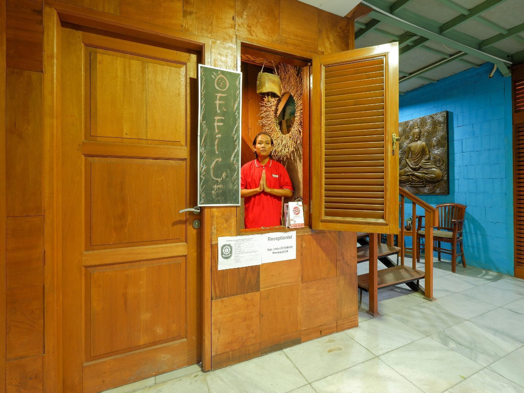 Zona de recepción con puerta de madera, un cartel que dice 