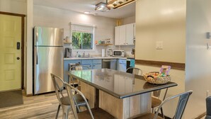 Una cocina moderna con una isla central, electrodomésticos de acero inoxidable y un ventanal que proporciona luz natural.
