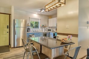 A modern kitchen with a central island, stainless steel appliances, and a window providing natural light.