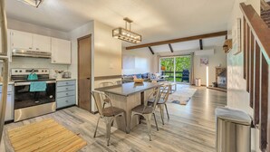 Una cocina moderna con una isla central, electrodomésticos de acero inoxidable y una zona de comedor con sillas.