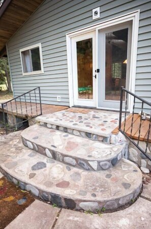 Stunning stone staircase leads to a welcoming front door with a glass panel.
