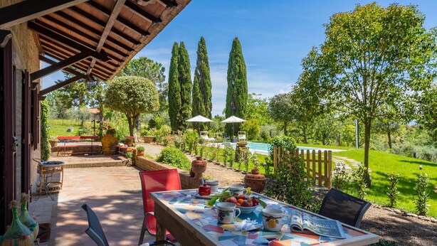 An outdoor patio with a table set for dining, surrounded by greenery and tall trees. - Villa in Gambassi with pool, A/C, village and restaurant at walking distance, (Gambassi Terme)
