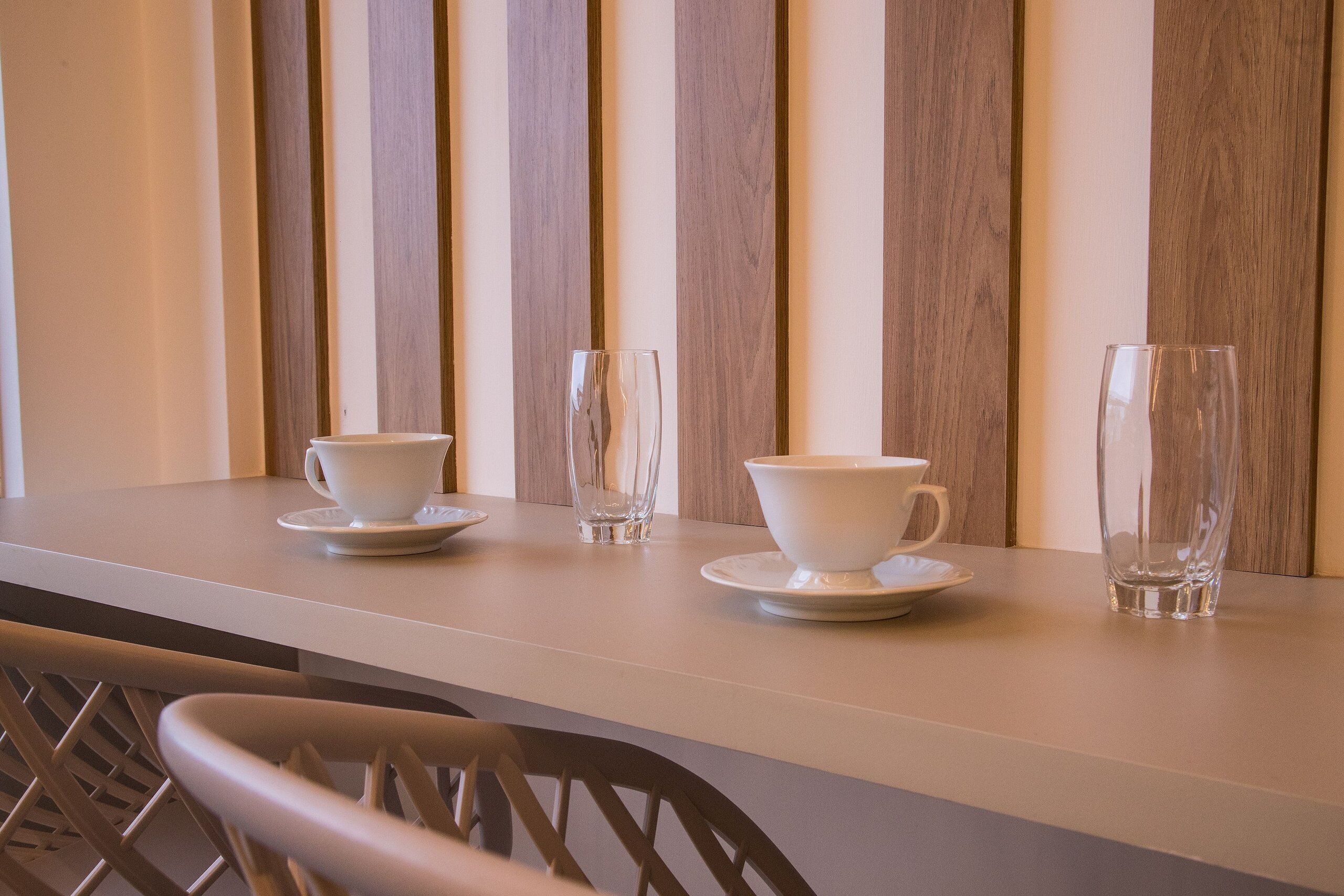 A clean, modern dining area with a long table and chairs.