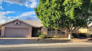 home with a tree-lined front yard and a garage.