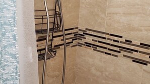 A shower with a handheld showerhead and a wall-mounted control panel. - Tranquilo y Comodo. (Compton)
