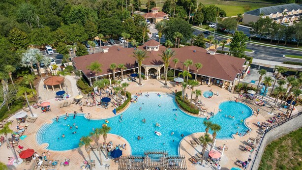 Eine Luftaufnahme eines Resorts mit mehreren Schwimmbecken, Liegebereichen und einer überdachten Schutzhütte.