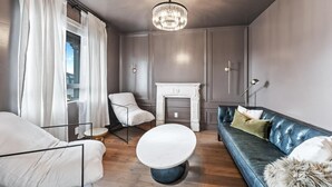 A modern living room with a fireplace, a sofa, a chair, and a round coffee table. - Home in American Fork - Lakeshore (Highland)