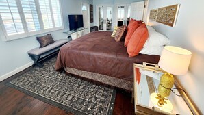 A bedroom with a large bed, a TV, a ceiling fan, and a rug. - Sea Gem-2/2 half duplex with quick ocean access, dockage  (Marathon)