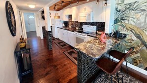 A modern kitchen with white cabinets, a granite countertop, and a built-in oven. - Sea Gem-2/2 half duplex with quick ocean access, dockage  (Marathon)