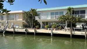 A waterfront hotel with a pool, outdoor seating, and a covered area with plants. - Sea Gem-2/2 half duplex with quick ocean access, dockage  (Marathon)