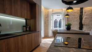 Una cocina moderna con armarios de madera, encimera de mármol e iluminación colgante.
