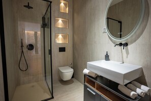 A modern bathroom with a glass-enclosed shower, a toilet, and a vanity with a mirror. - Historic apartment in a pedestrian zone, 50 meters from the sea. (Parenzo)