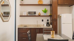 Una cocina compacta equipada con microondas, cafetera y refrigerador.