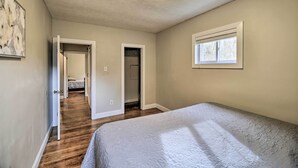 Un dormitorio con una cama, un armario y un pasillo que conduce a otra habitación.