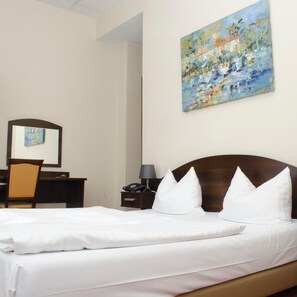 A hotel room with a bed, a desk, a chair, a nightstand, a lamp, and a painting on the wall. - Hotel Polo Am Zob (Hamburg)