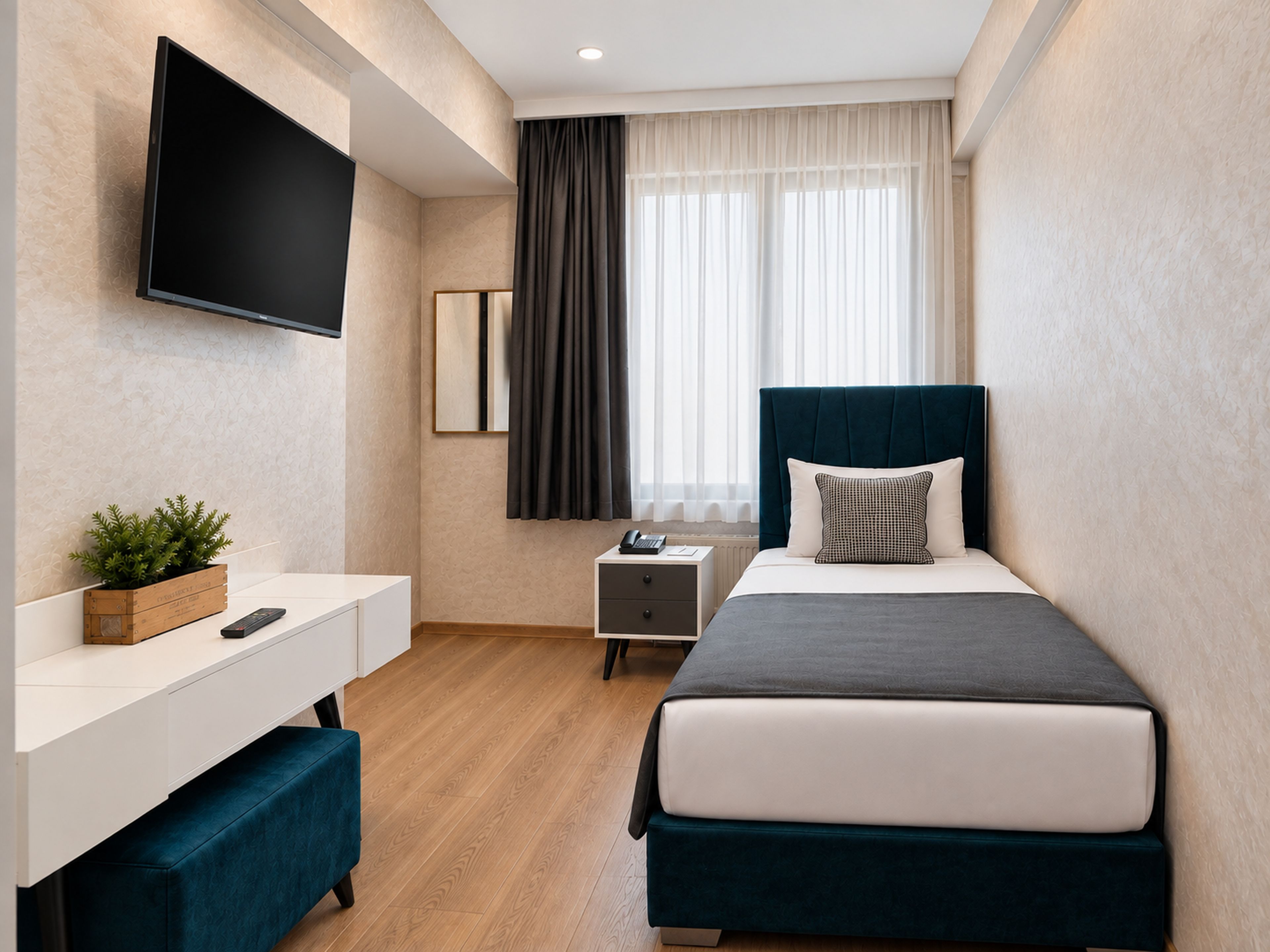 A modern hotel room with a bed, bedside table, TV, and a window with curtains.