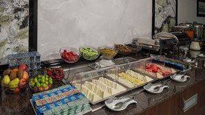 Un bufé con diversos alimentos y bebidas, incluyendo frutas, verduras y productos lácteos.
