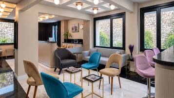 A modern interior with a seating area, a kitchen, and large windows.