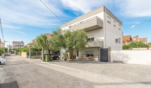 A modern two-story building with a flat roof and a balcony on the upper floor. - Modern two bedroom apartment with shared pool (Zadar)