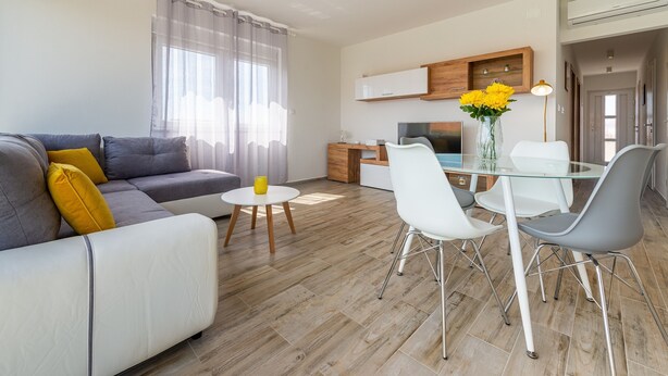 Ein modernes Wohnzimmer mit einer Couch, einem Esstisch und Stühlen.