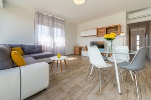 Ein modernes Wohnzimmer mit einer Couch, einem Esstisch und Stühlen.