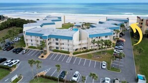 A hotel with a parking lot, a pool, and a view of the ocean. - Gorgeous Condo with Ocean Views in St. Augustine (St. Augustine)