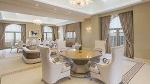 A spacious, elegantly furnished room with a round dining table, white upholstered chairs, and a chandelier. - Gabala Garden Hotel (Gabala)