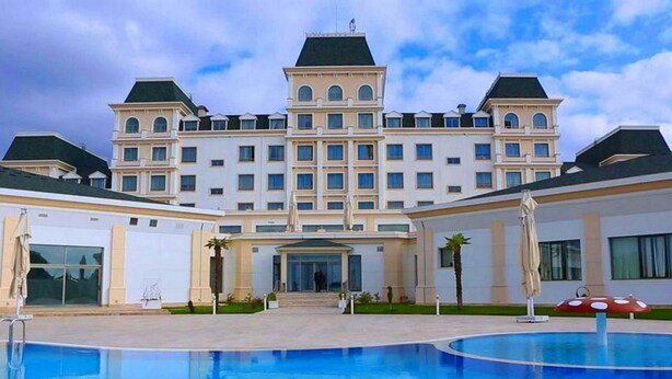 A large hotel with a central courtyard, a swimming pool, and a symmetrical facade with multiple windows and balconies. - Gabala Garden Hotel (Gabala)
