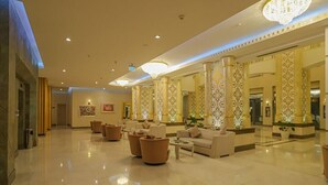A spacious lobby with a high ceiling, ornate columns, and a chandelier. There are several sofas and a coffee table. - Gabala Garden Hotel (Gabala)