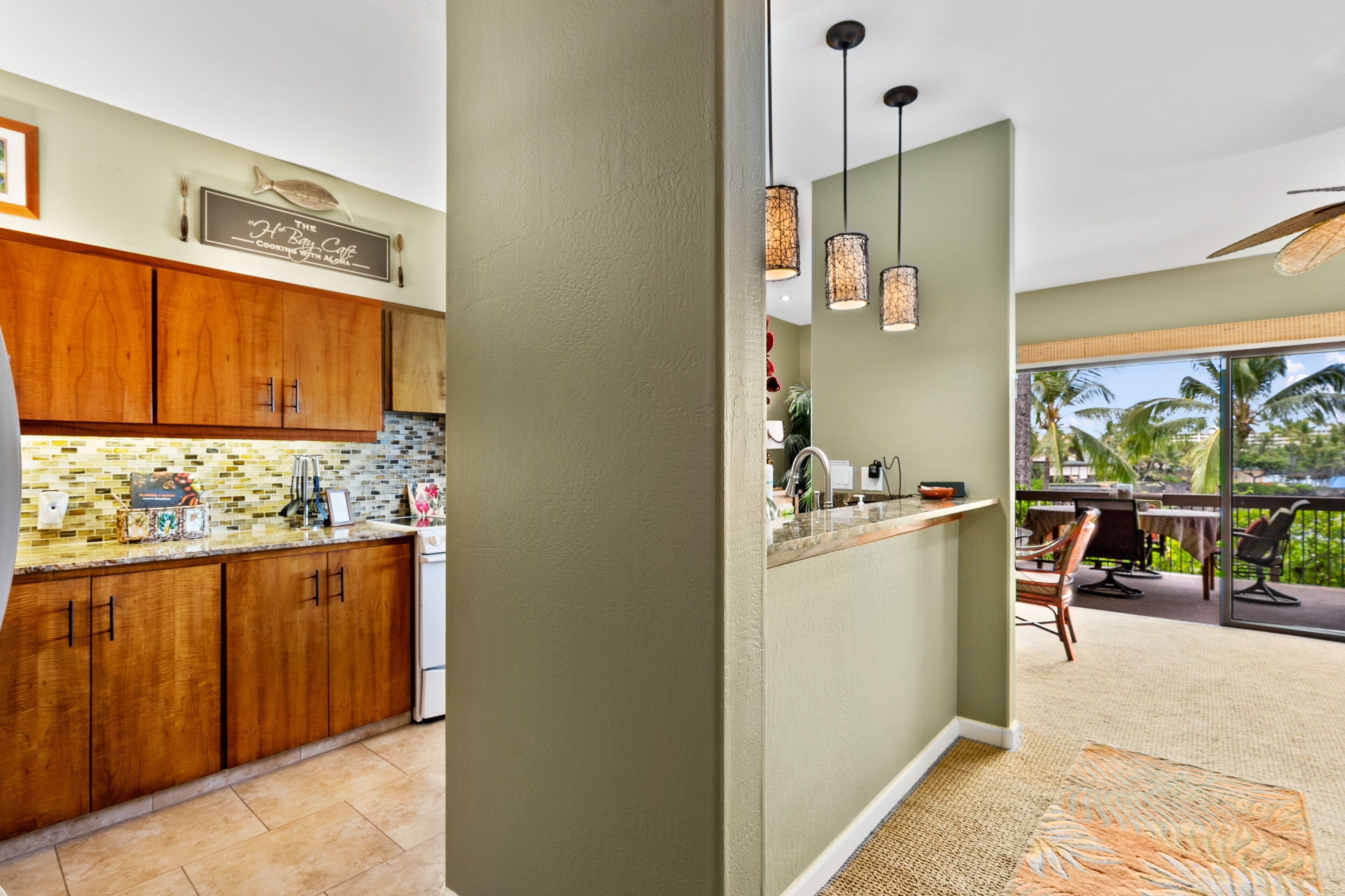 A kitchen with wooden cabinets, a tiled backsplash, and pendant lighting.