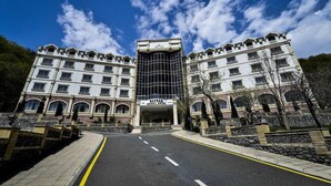 A hotel with a central entrance, multiple floors, and a modern glass facade. - Qafqaz Resort (Gabala)