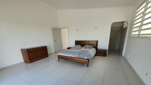 Ein Schlafzimmer mit einem Bett, einem Schminktisch und einem Nachttisch.