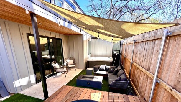 Patio con piscina, terraza de madera y zona de estar al aire libre.
