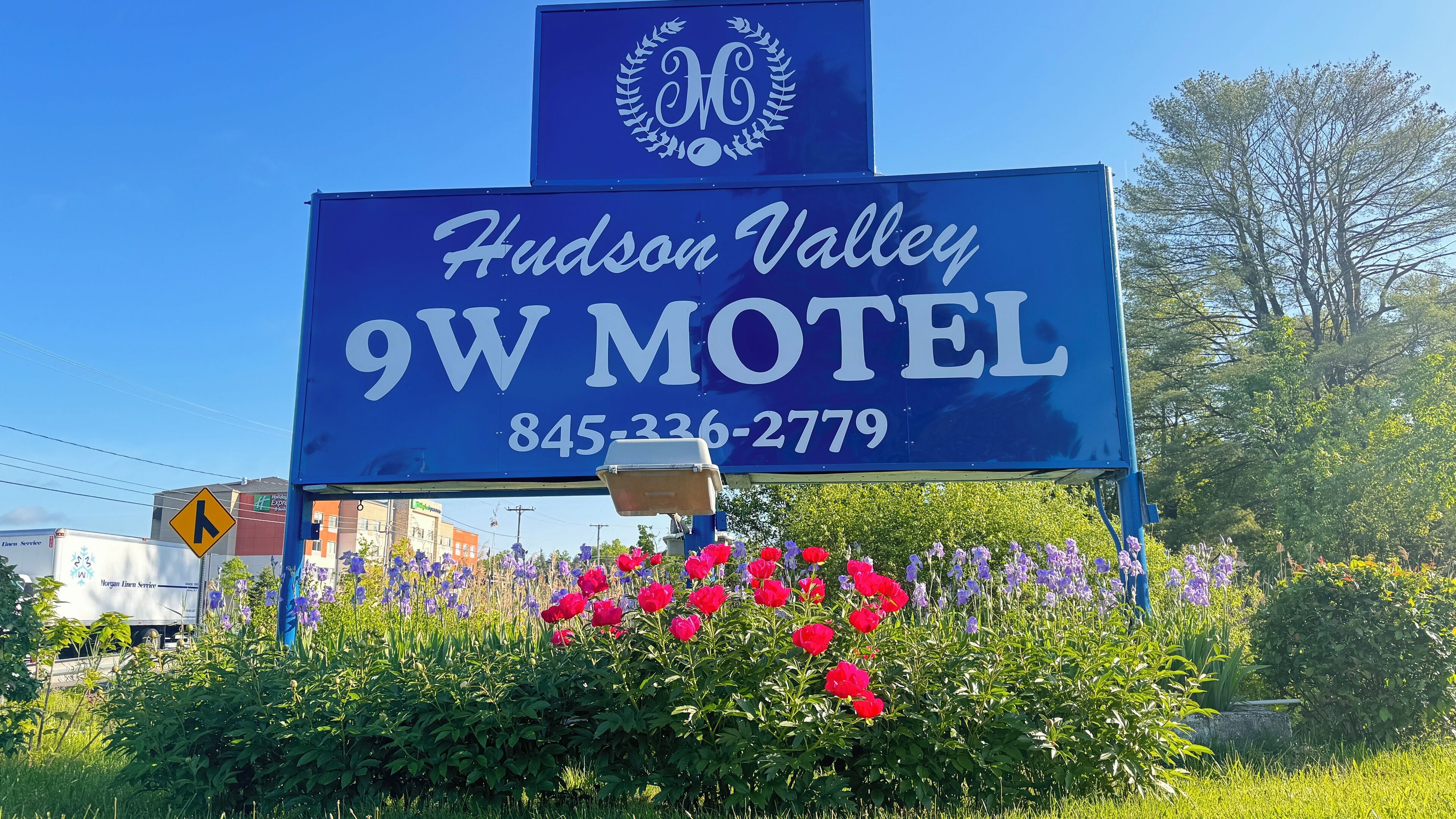 A blue sign for Hudson Valley 9W Motel with a phone number.