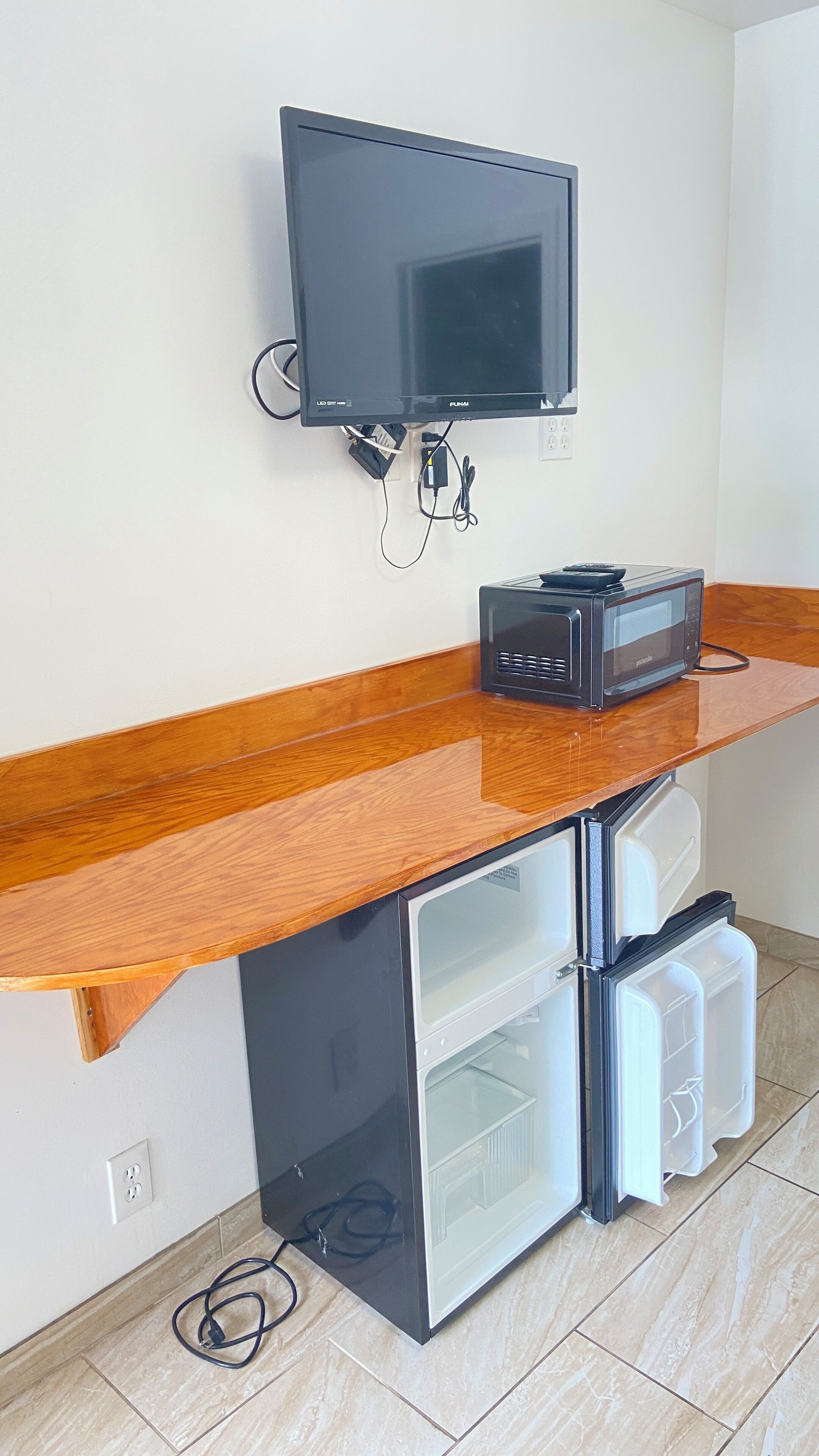 A kitchenette with a flat-screen TV, a microwave, and two mini-fridges.