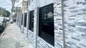 A building with a stone facade, multiple windows, and visible electrical wires.