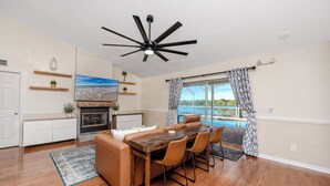 Una cocina moderna con comedor, chimenea y vista a una piscina.