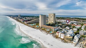 A coastal cityscape with a beachfront hotel, high-rise buildings, and a clear view of the ocean. -  Private Beach Access, Pool and Hot Tub! (Destin)