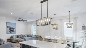 A modern kitchen with a central island, white cabinetry, and pendant lighting. -  Private Beach Access, Pool and Hot Tub! (Destin)