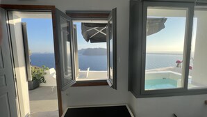 Ein Zimmer mit einem großen Fenster mit Blick auf das Meer und eine Klippe.